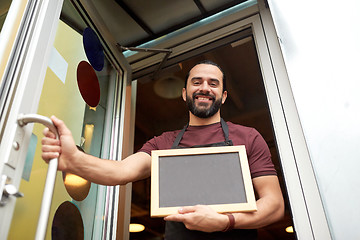 Image showing man or waiter with blackboard at bar entrance door