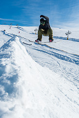 Image showing Snowboarder jumping against blue sky