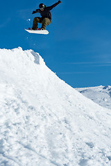 Image showing Snowboarder jumping against blue sky