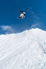 Image showing Snowboarder jumping against blue sky