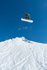 Image showing Snowboarder jumping against blue sky