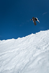 Image showing Snowboarder jumping against blue sky