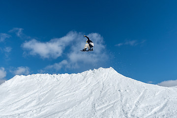 Image showing Snowboarder jumping against blue sky