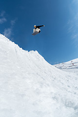 Image showing Snowboarder jumping against blue sky