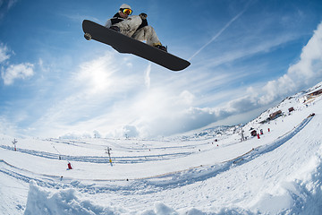 Image showing Snowboarder jumping against blue sky