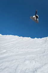 Image showing Snowboarder jumping against blue sky