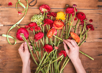 Image showing Ranunkulyus bouquet of red flowers on a wooden background