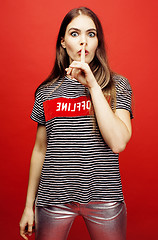 Image showing young pretty emitonal posing teenage girl on bright red background, happy smiling lifestyle people concept 
