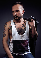 Image showing A man with tattooes on his arms. Silhouette of muscular body. caucasian brutal hipster guy with modern haircut, looking like criminal 