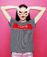 Image showing young pretty teenage woman emotional posing on pink background, fashion lifestyle people concept 