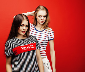 Image showing two best friends teenage girls together having fun, posing emotional on red background, besties happy smiling, lifestyle people concept 