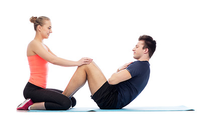 Image showing happy sportive man and woman doing sit-ups