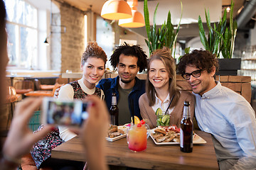 Image showing friends with smartphone photographing at cafe