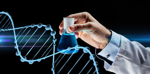 Image showing close up of scientist holding flask with chemical