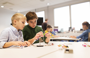 Image showing happy children building robots at robotics school