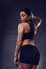 Image showing young woman posing and showing buttocks in gym