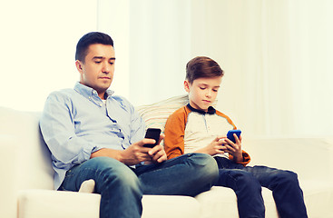 Image showing father and son with smartphones at home