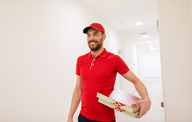 Image showing happy delivery man with pizza boxes in corridor