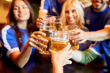 Image showing football fans clinking beer glasses at sport bar