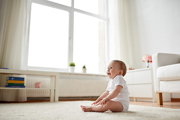 Image showing happy baby boy or girl sitting on floor at home