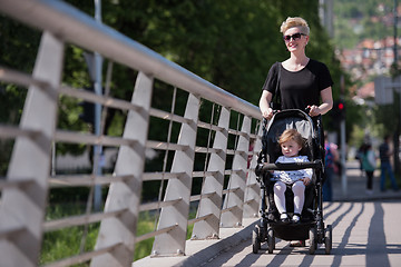 Image showing mother pushed her baby daughter in a stroller