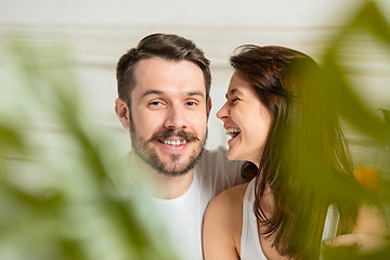 Image showing Young adult heterosexual couple lying on bed in bedroom