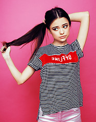 Image showing young pretty teenage woman emotional posing on pink background, fashion lifestyle people concept 