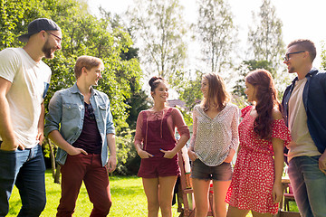 Image showing happy teenage friends talking at summer garden