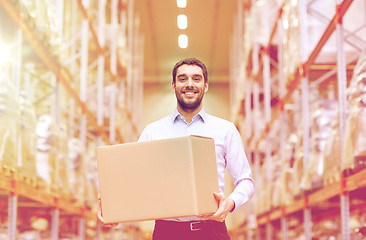 Image showing happy man with cardboard parcel box at warehouse