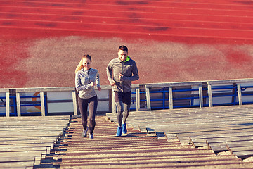 Image showing happy couple running upstairs on stadium