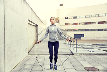 Image showing woman exercising with jump-rope outdoors