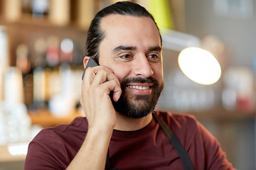 Image showing happy man or waiter at bar calling on smartphone