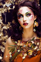 Image showing beauty woman with face art and jewelry from flowers orchids clos