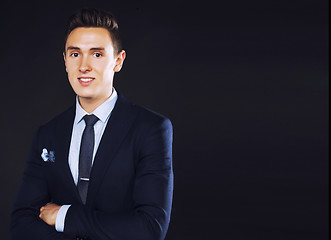 Image showing young pretty business man standing on black background, modern h