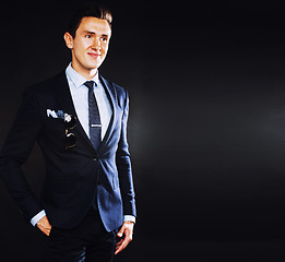 Image showing young pretty business man standing on black background, modern h