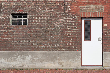 Image showing White wooden door in a red brick wall