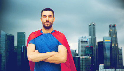 Image showing man in red superhero cape over city background