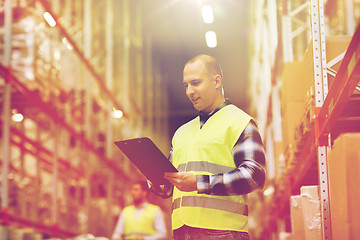 Image showing man with clipboard in safety vest at warehouse