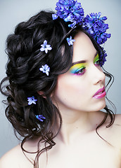 Image showing Beauty young woman with flowers and make up close up, real sprin