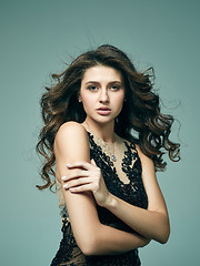 Image showing Pretty girl with long hair posing at studio