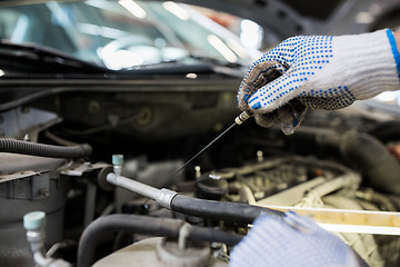 Image showing mechanic with dipstick checking motor oil level