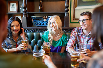 Image showing happy friends drinking beer at bar or pub