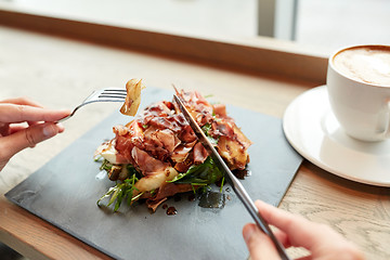 Image showing woman eating prosciutto ham salad at restaurant