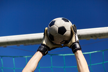 Image showing goalkeeper with ball at football goal over sky