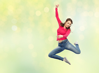 Image showing smiling young woman jumping in air