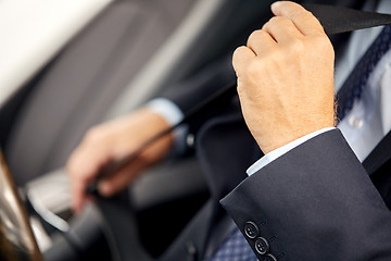 Image showing senior businessman fastening car seat belt