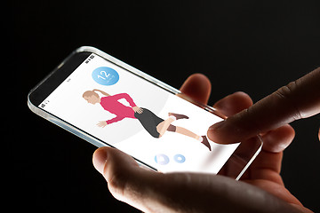 Image showing close up of hands with fitness app on smartphone