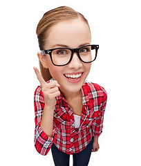 Image showing smiling teenager in eyeglasses with finger up