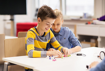 Image showing happy children building robots at robotics school