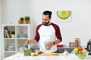 Image showing man with blender cup cooking food at home kitchen